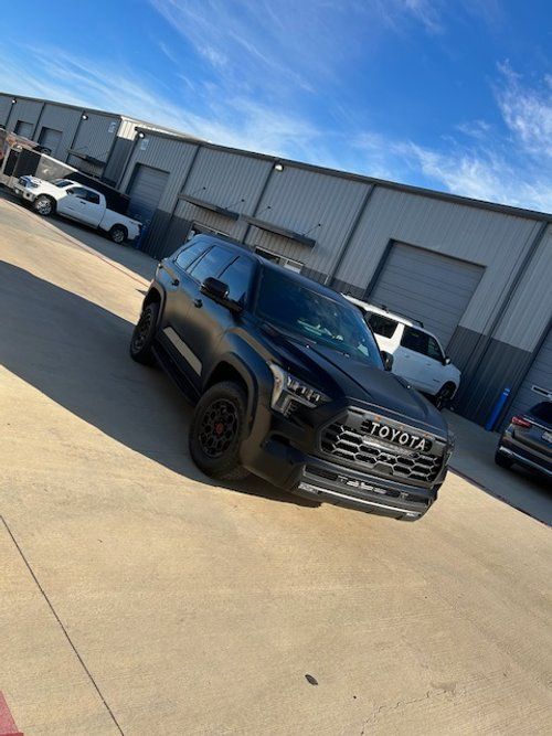 A black toyota suv is parked in front of a building.