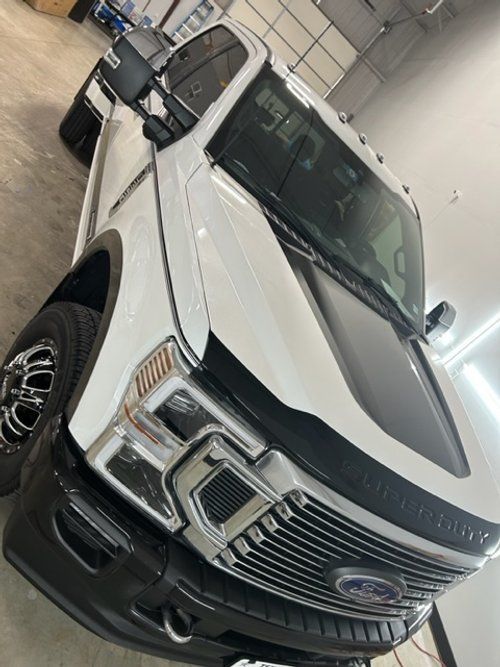 A white ford truck is parked in a garage.
