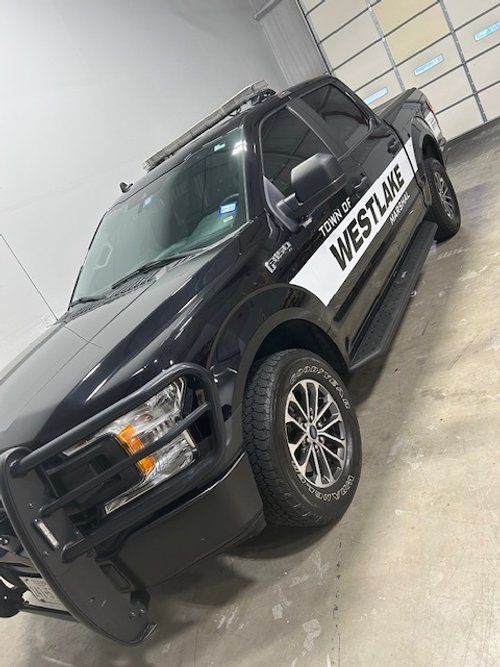 A black truck with the word westlake on the side is parked in a garage.