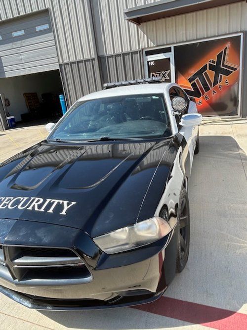 A black car with the word security on the hood