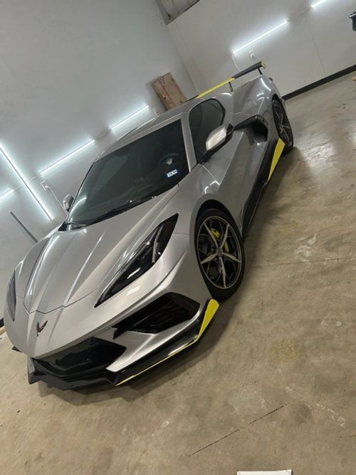 A silver sports car is parked in a garage.