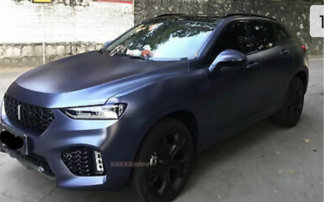 A blue car is parked on the side of the road.