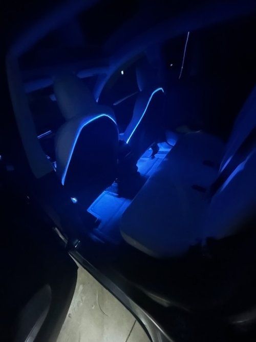 The inside of a car with blue lights on the seats