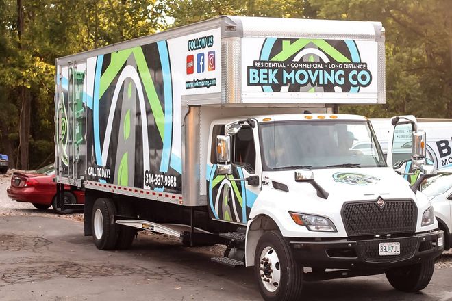 BEK Moving Co. truck with colorful graphics parked outdoors on a muddy street