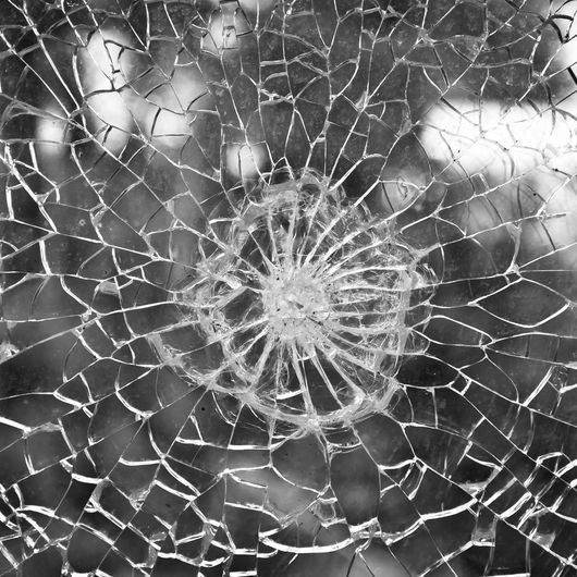 A black and white photo of a broken glass window