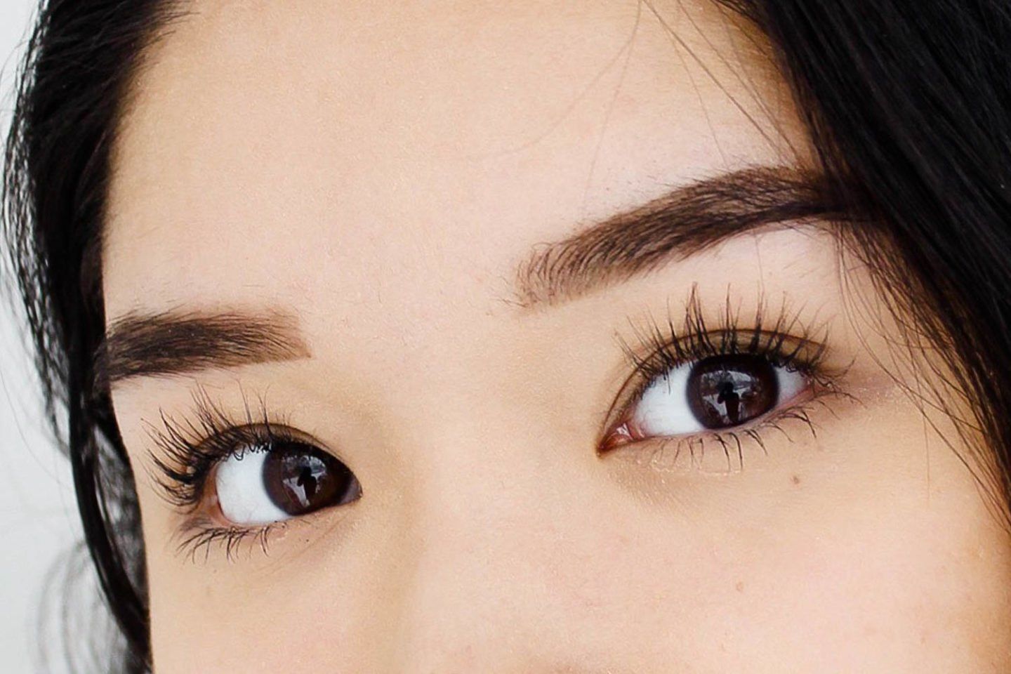 A close up of a woman 's eyes with long eyelashes.