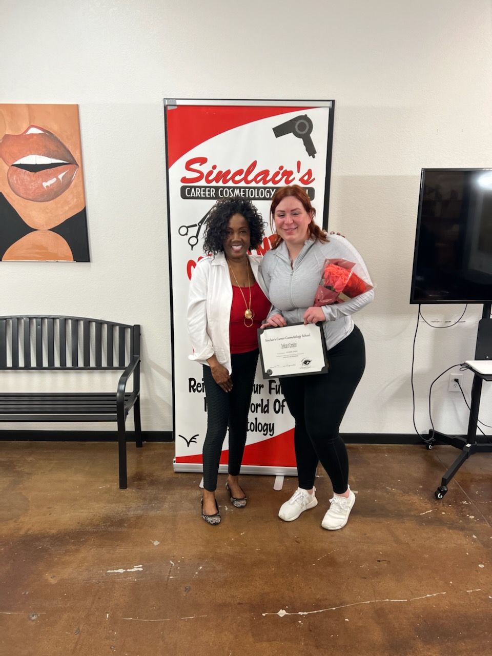 Two women are posing for a picture in front of a sinclair 's sign