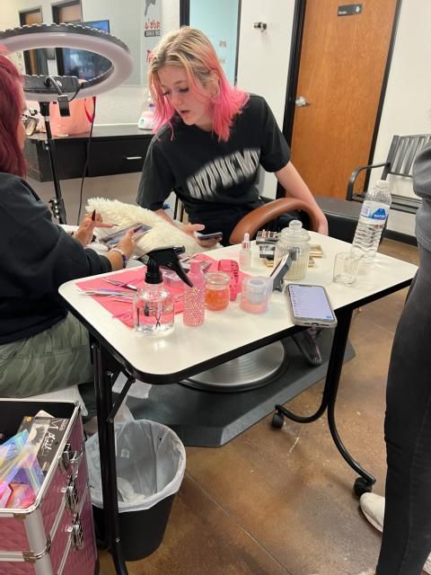 A woman wearing a supreme shirt sits at a table