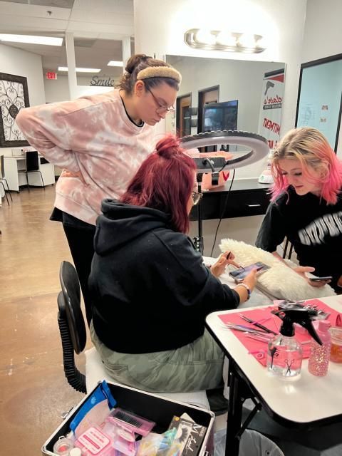 A group of women are sitting at a table in a salon