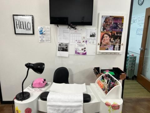 A room with a table and chairs and a tv on the wall.