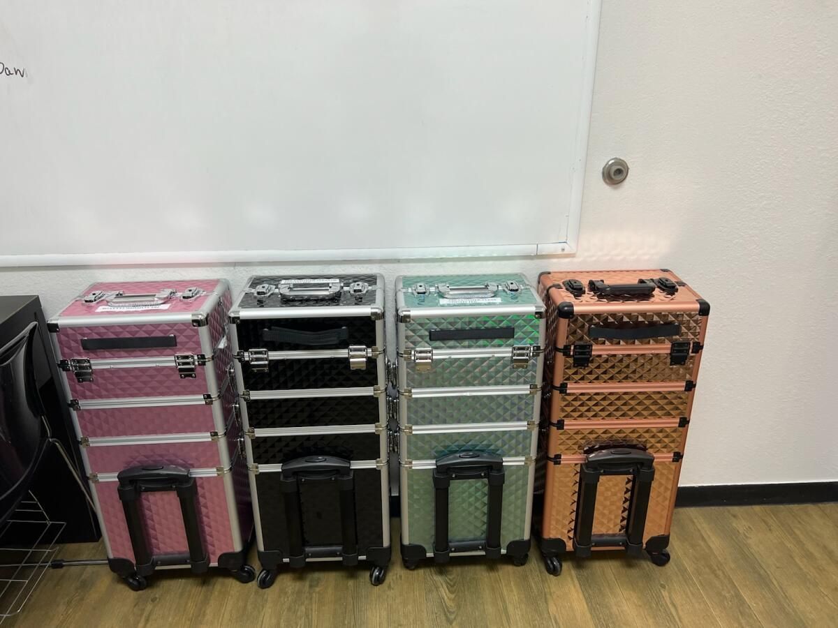 Four luggage cases are lined up in a row on a wooden floor.