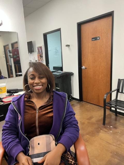 A woman in a purple jacket is sitting in a chair
