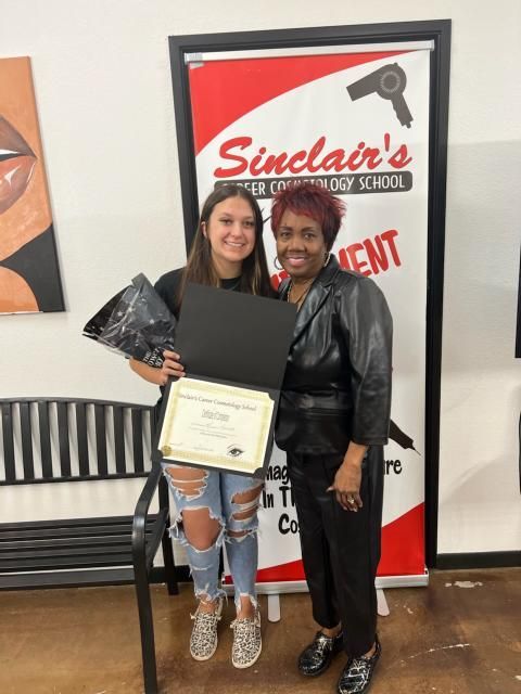 Two women standing in front of a sinclair 's sign