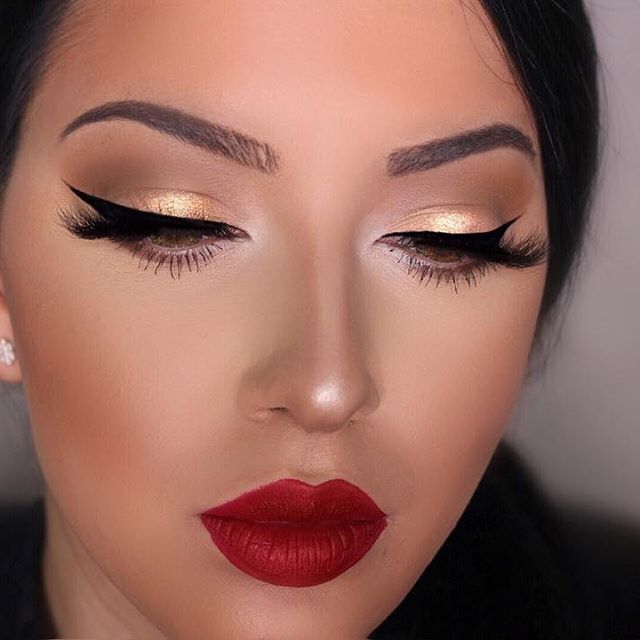 A close up of a woman 's face with makeup and red lips.