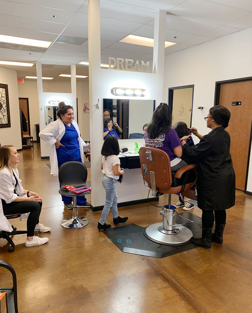 A group of people are getting their hair done in a salon.