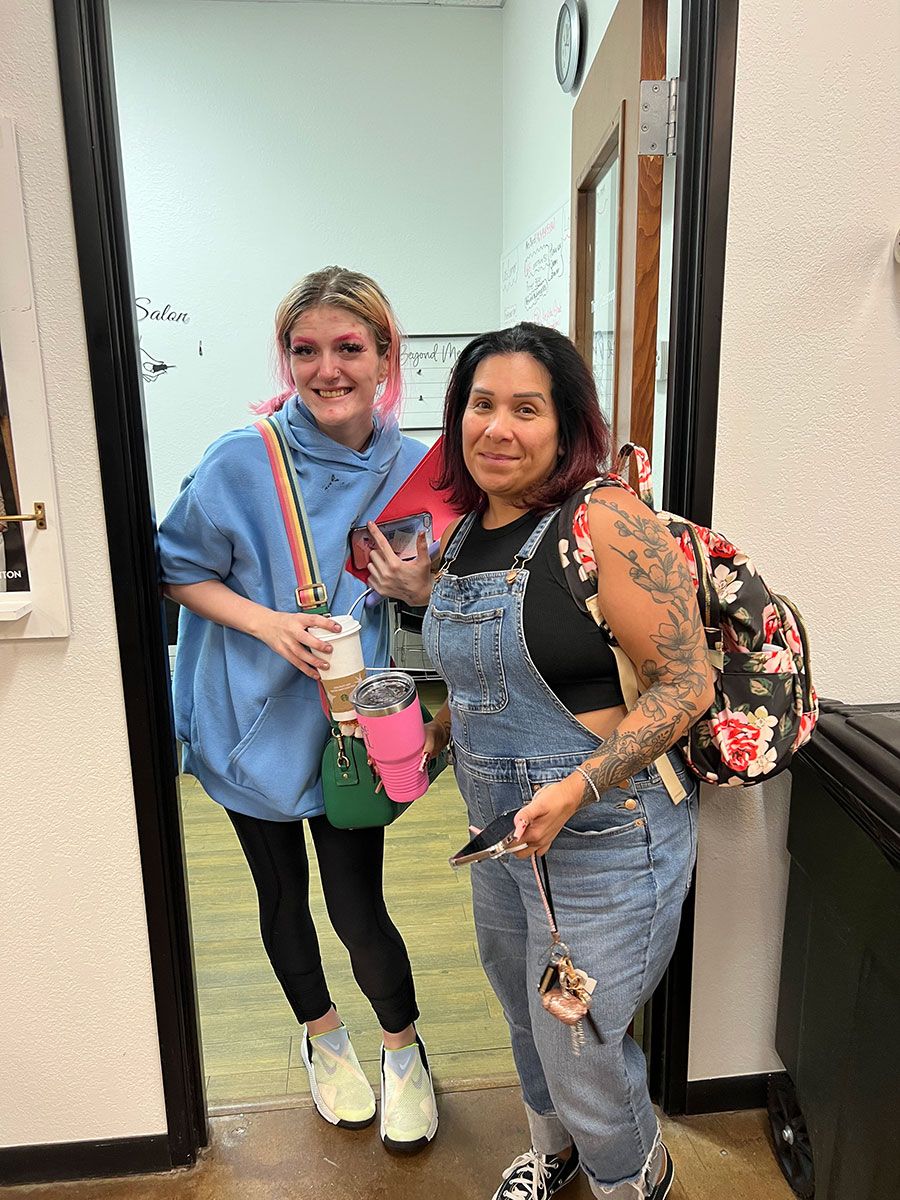 Two women are standing next to each other in a doorway.