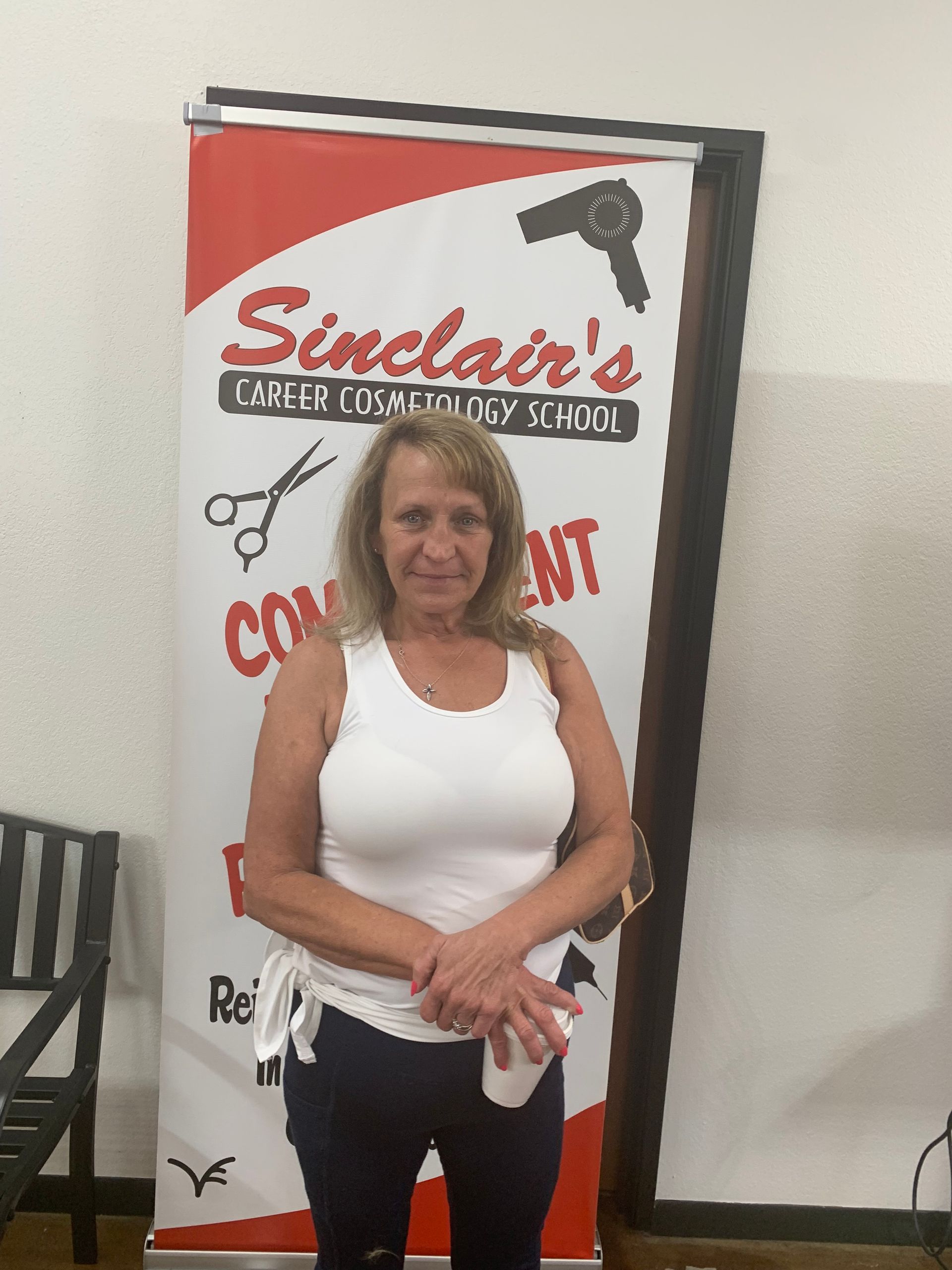 A woman standing in front of a sinclair 's sign