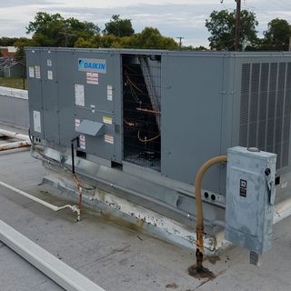 A daikin air conditioner is sitting on top of a roof