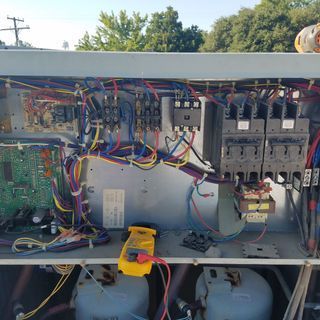 The inside of a electrical box with a voltmeter on top of it.