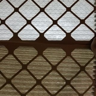 A close up of a metal fence with a diamond pattern on it.