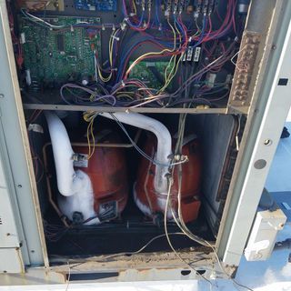 The inside of an air conditioner with a lot of wires coming out of it.