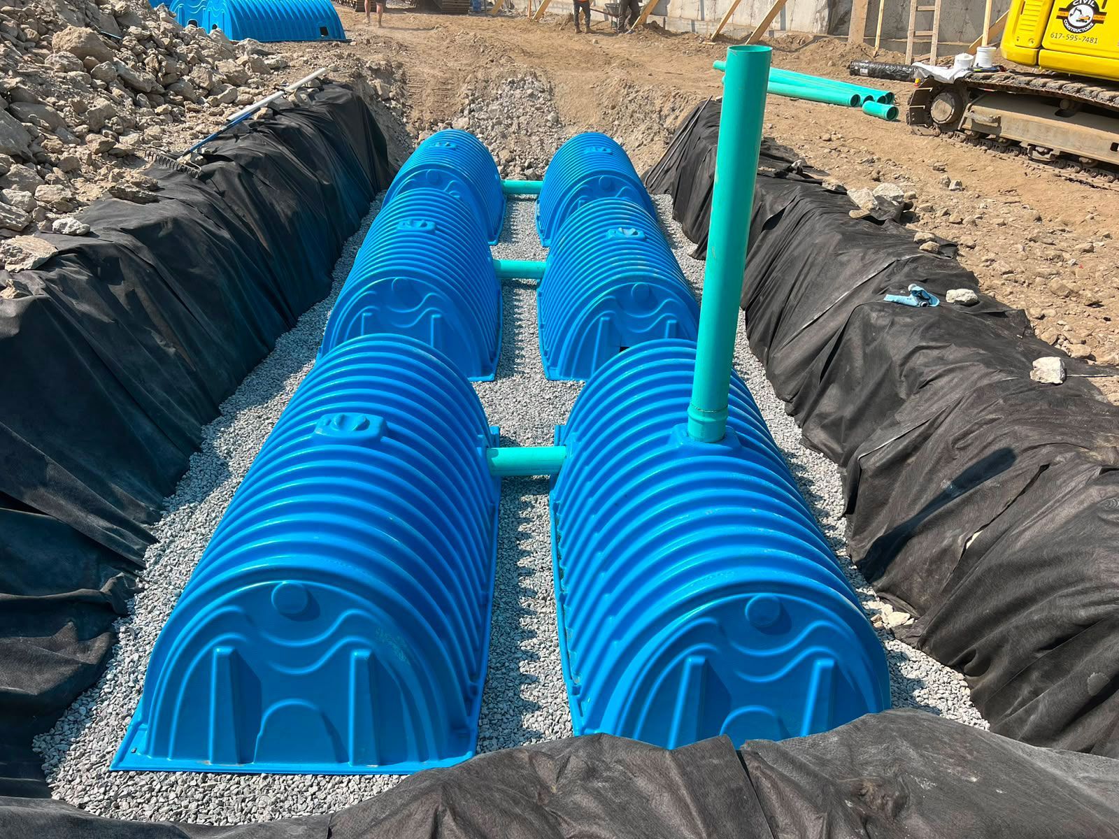 Blue corrugated drainage pipes installed in a trench at a construction site
