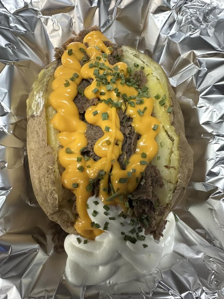 a baked potato with cheese and sour cream on it