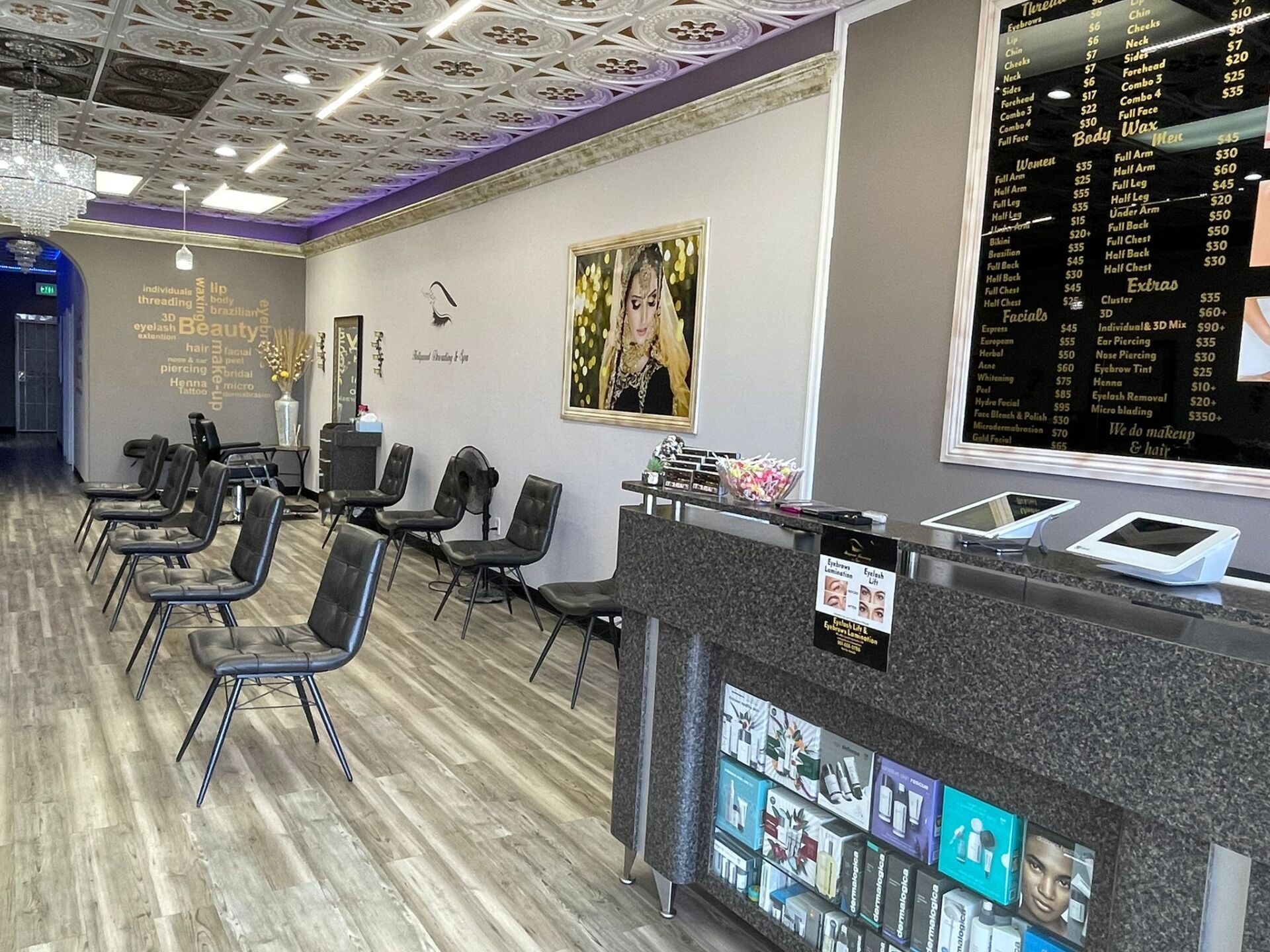 Interior of a nail salon with chairs, a front desk, and a menu board.
