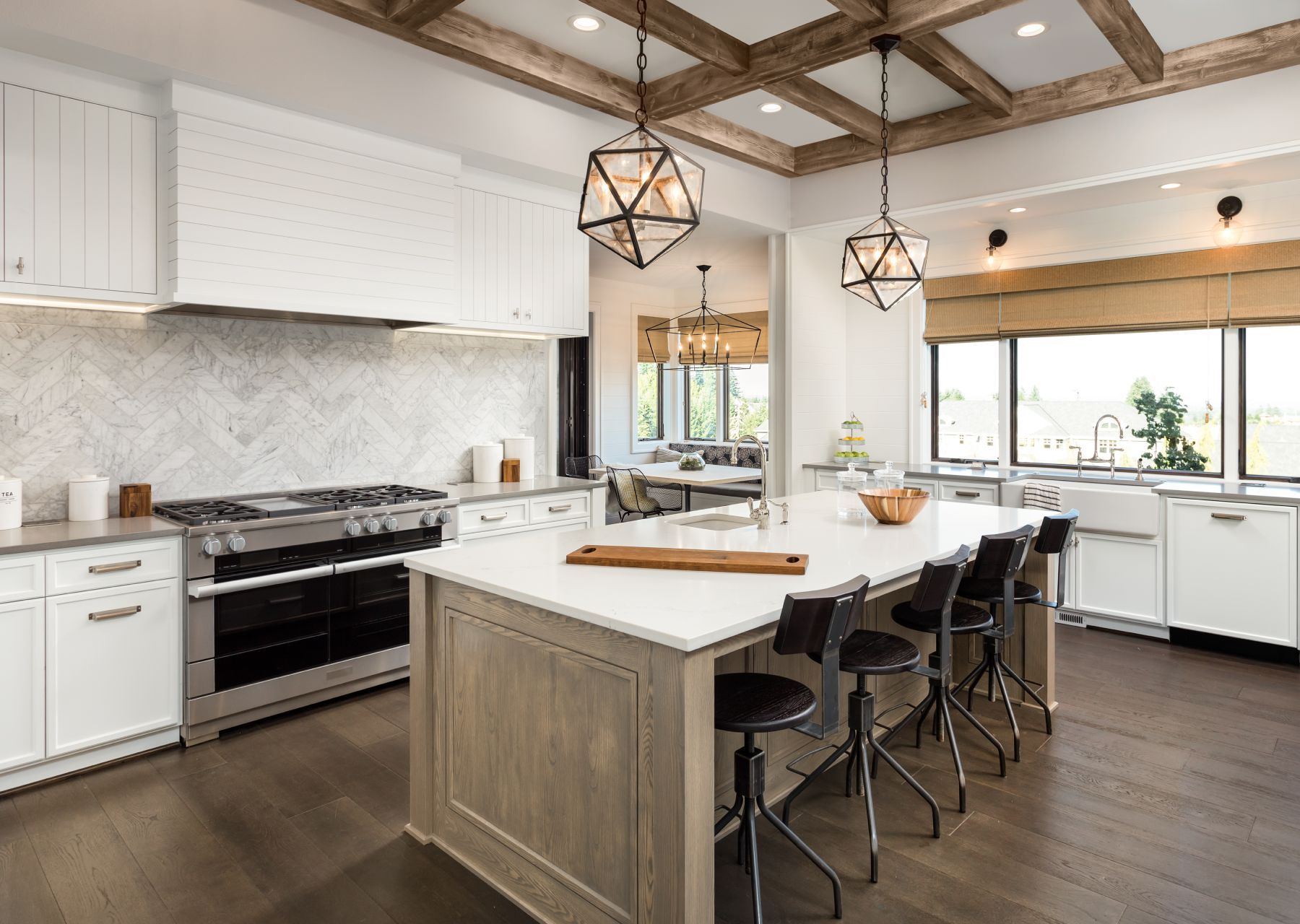 A kitchen with granite counter tops , white cabinets , stainless steel appliances and a large island.