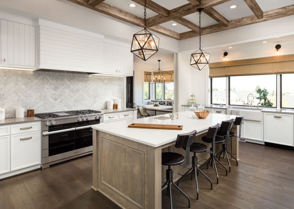 A kitchen with granite counter tops , white cabinets , stainless steel appliances and a large island.