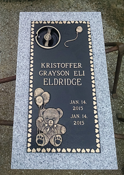 Bronze plaque on a gray granite base for Kristoffer Grayson Eli Eldridge, featuring a teddy bear and balloon decorations.
