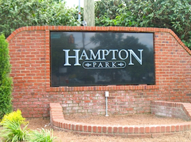 A brick monument sign with a black panel reading 