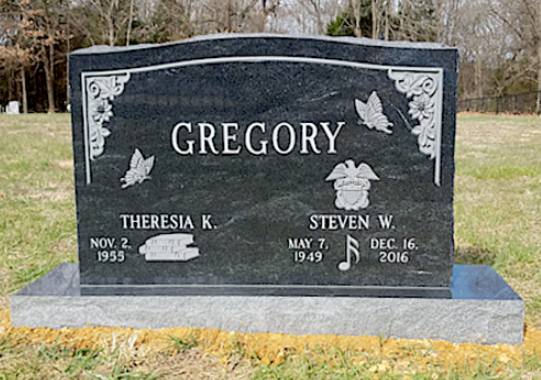 A black granite tombstone engraved 