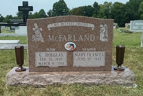 A granite headstone for G. Douglas and Mary Frances McFarland in a cemetery, featuring their names, dates, and a photo.