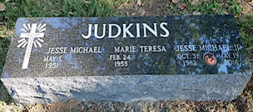A black granite tombstone engraved with 