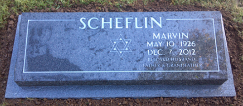 A dark blue granite gravestone for Marvin Scheflin, featuring a Star of David, dates 1926-2012, and family inscriptions.