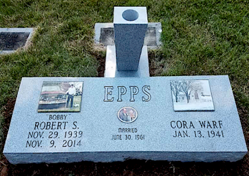 A gray granite cemetery headstone for Robert S. and Cora Warf Epps, featuring two inset photos and a central vase.