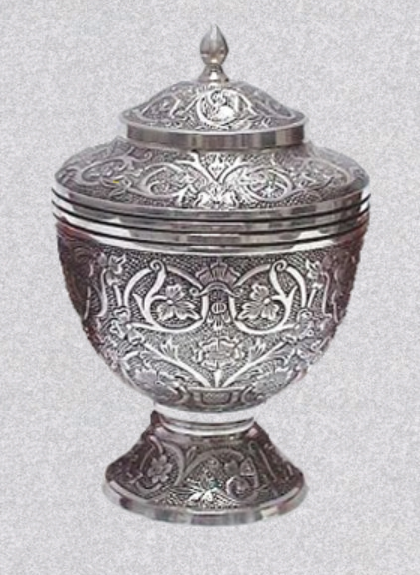 A silver-toned decorative lidded chalice or goblet featuring intricate, embossed floral and scrollwork designs.
