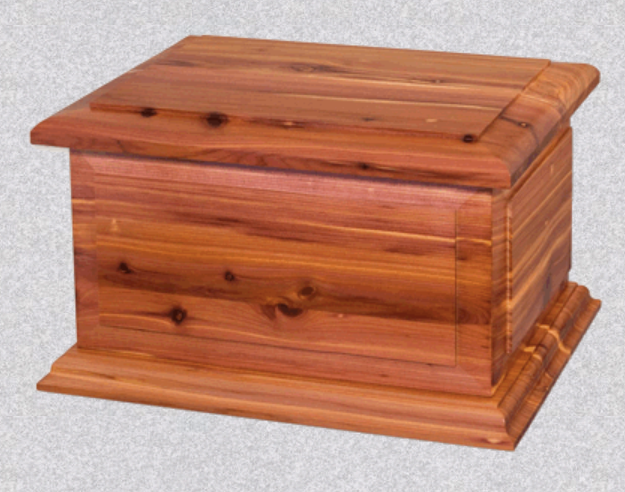 A rectangular, reddish-brown wooden cremation urn with a raised lid and a stepped base on a light gray background.
