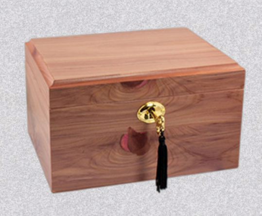 A wooden keepsake box with a light brown grain, featuring a prominent brass lock and a dangling black tassel.