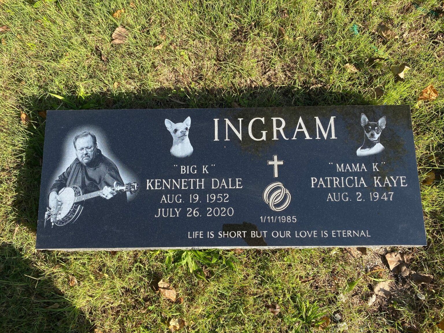 A black granite gravestone for the Ingram family, featuring an etched portrait, dog portraits, and memorial dates.