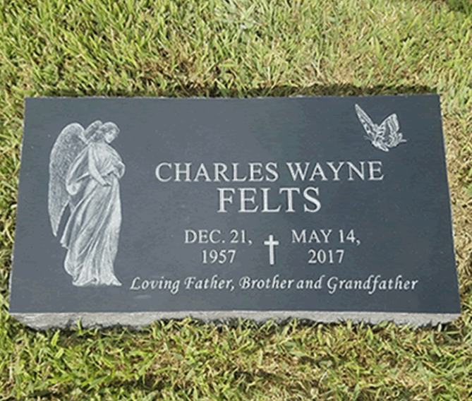 A black granite grave marker for Charles Wayne Felts (1957–2017) featuring an engraved angel and butterfly in grass.