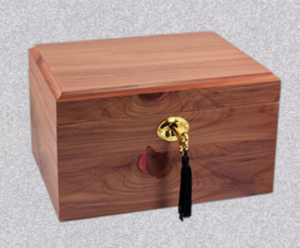 A rectangular wooden chest made of cedar, featuring a brass keyhole with a hanging black tassel.