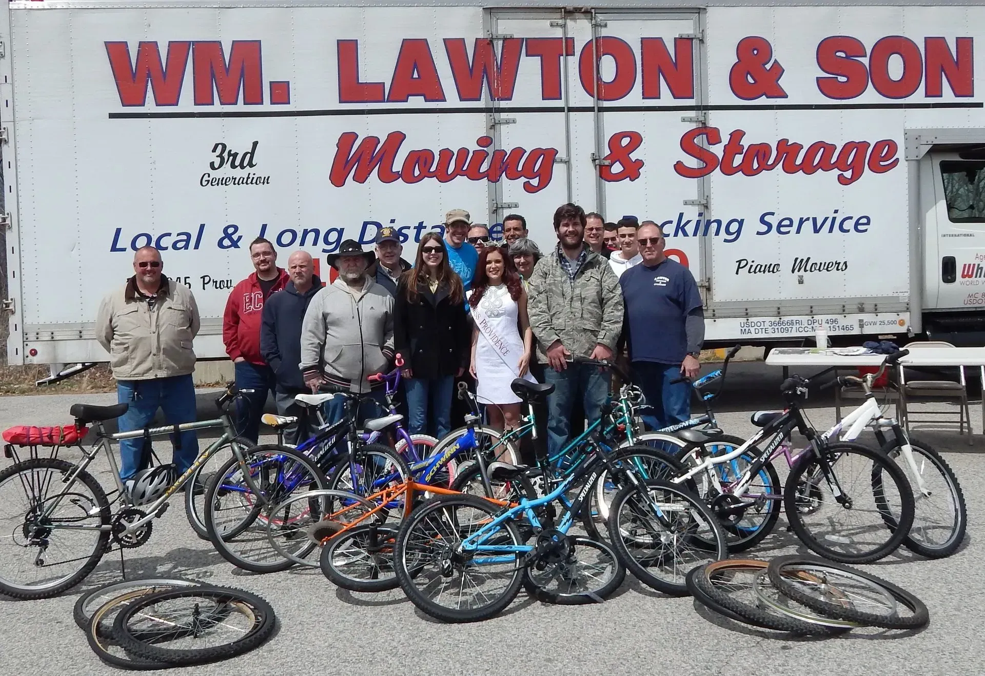 Group of people with bicycles in front of a moving truck, 