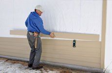 A man installing a house siding