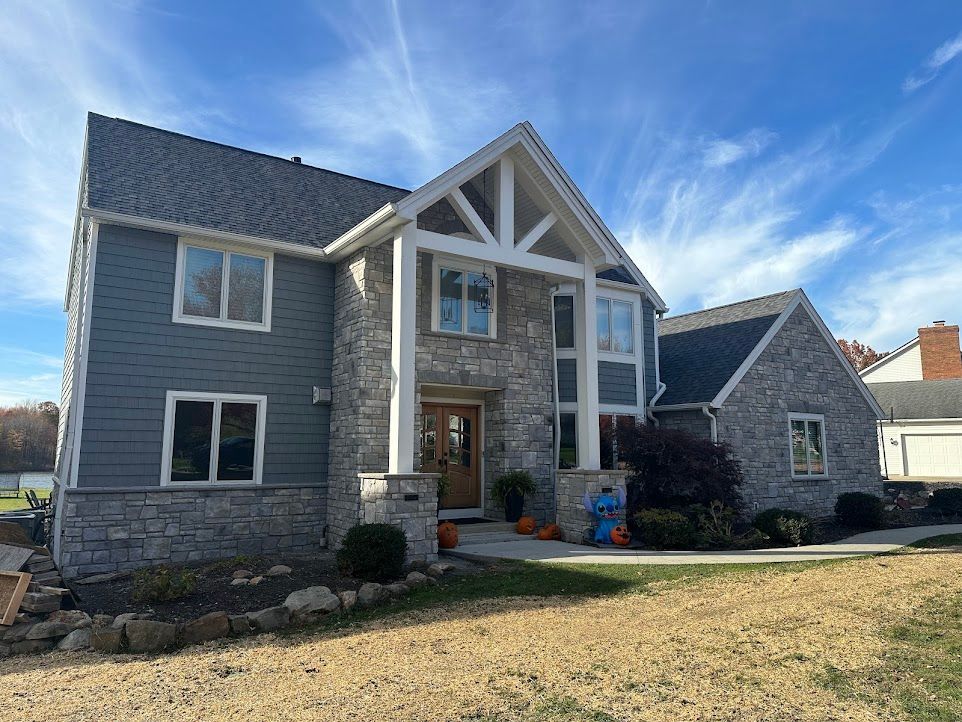 A large house with a lot of windows and pumpkins in front of it.