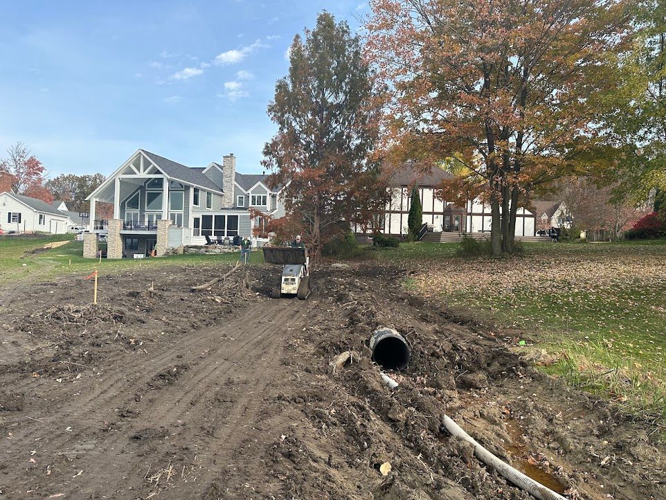 A large house is in the background of a dirt road.