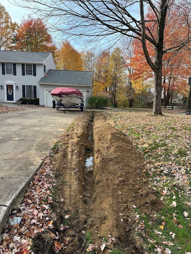 A boat is parked in a driveway next to a house.