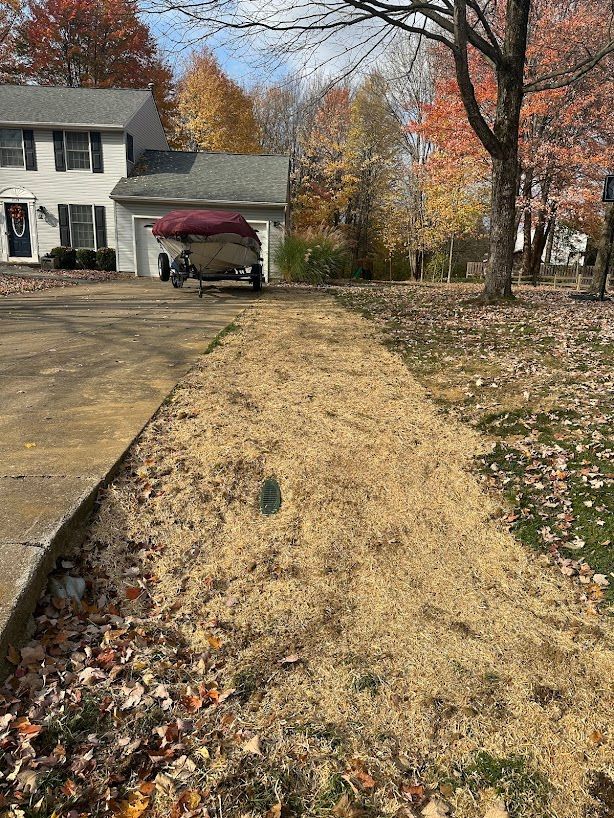 A boat is sitting in the driveway of a house.
