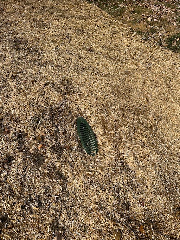 A green object is laying on the ground in the middle of a field.